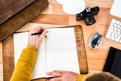 Above view of man writing on notebook
