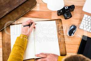 Above view of man writing on notebook