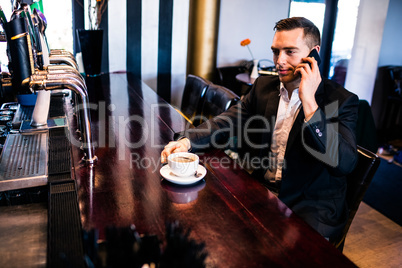 Businessman on the phone having a coffee