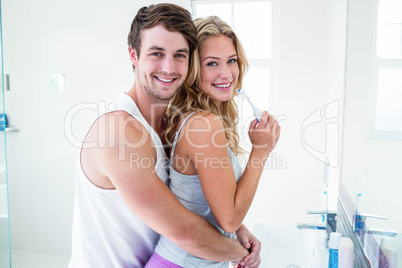 Young couple brushing their teeth at home