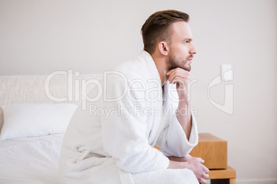 Serious man in bathrobe looking away