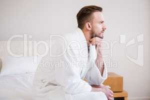 Serious man in bathrobe looking away