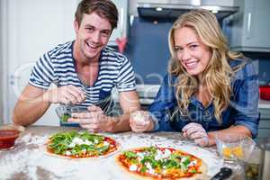 Smiling couple preparing pizza