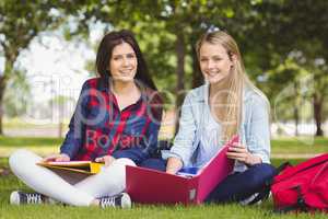 Smiling students holding binder