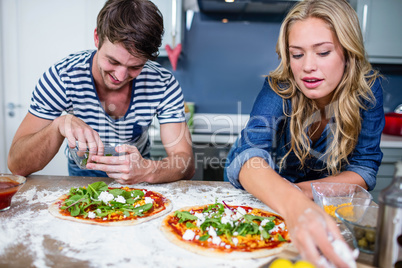 Smiling couple preparing pizza