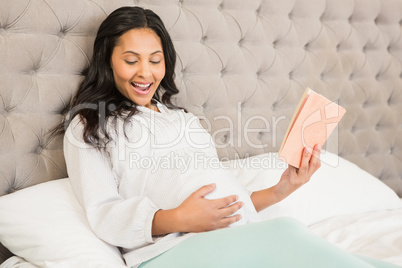 Pregnant brunette reading a book