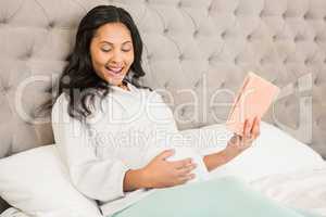 Pregnant brunette reading a book