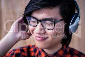 Smiling hipster listening music with headphone