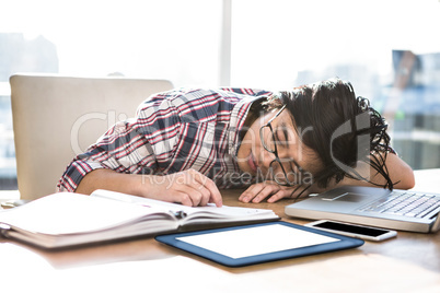 Hipster businessman falling asleep on desk