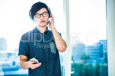 Concentrated asian businessman listening to music