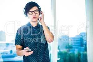 Concentrated asian businessman listening to music