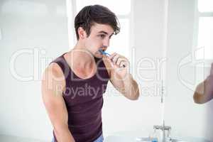 Handsome man cleaning his teeth