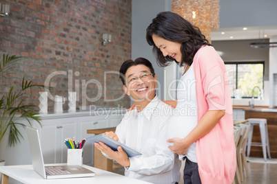 Happy couple using tablet