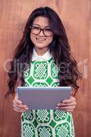 Smiling Asian woman holding tablet and looking at the camera