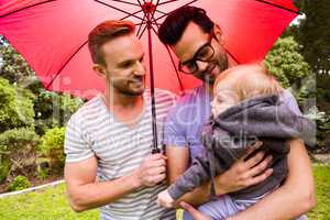 Smiling gay couple with child