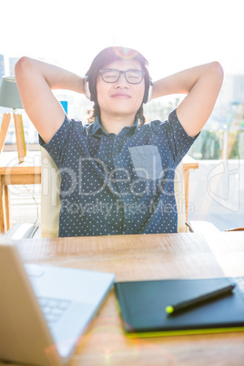 Smiling asian businessman listening to music