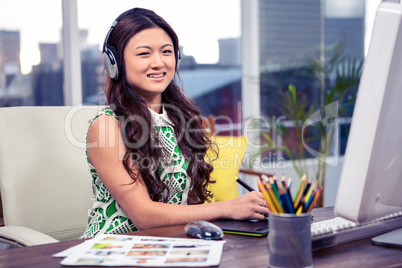 Asian woman with headphones using computer