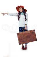 Smiling Asian woman holding luggage pointing somewhere