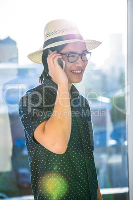 Smiling hipster using his phone