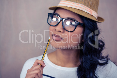 Attractive Asian woman with hat holding pencil