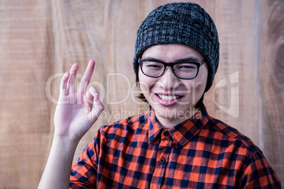 Smiling hipster making ok sign
