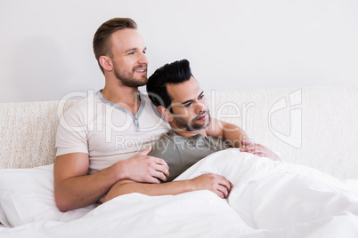 Asleep gay couple lying in bed