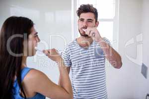 Couple brushing their teeth