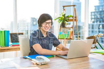 Smiling hipster businessman using laptop