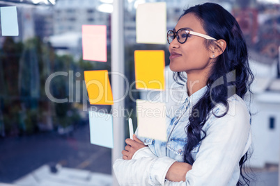 Asian woman looking at sticky notes