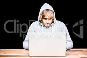 Man in hood jacket hacking a laptop
