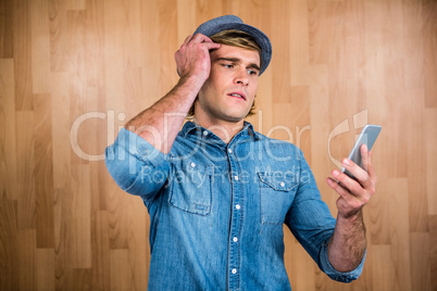 Concerned hipster looking at smartphone