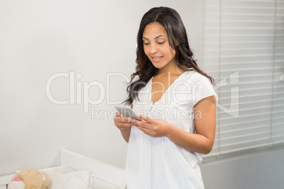 Smiling brunette using smartphone