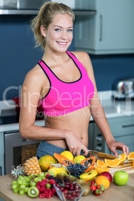 Fit woman cutting fruits