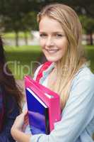 Smiling student holding binder