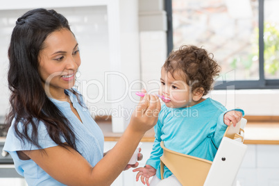 Happy brunette feeding her baby