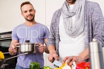 smiling gay couple preparing food