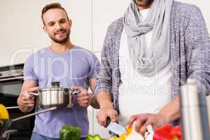 smiling gay couple preparing food