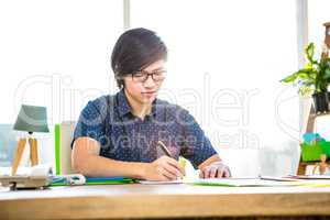 Focused hipster businessman writing