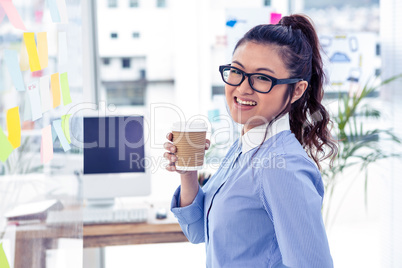 Businesswoman holding disposable cup and looking at wall with no