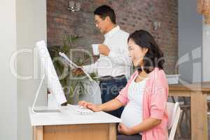Smiling pregnant woman using laptop