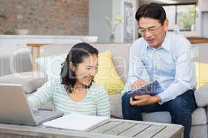 Happy couple using laptop and tablet