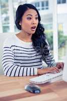 Surprised Asian woman using computer