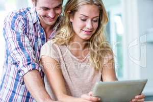 Cute couple using tablet computer in the kitchen