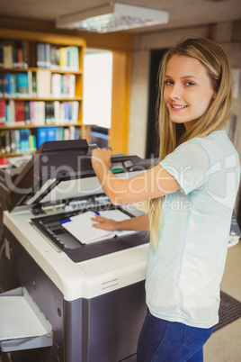 Smiling blonde student making a copy