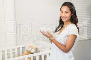 Smiling brunette holding baby shoes