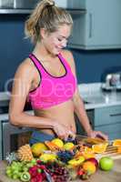 Fit woman cutting fruits