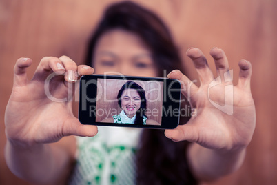 Smiling Asian woman taking selfie