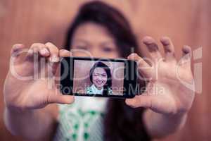 Smiling Asian woman taking selfie