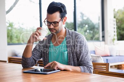 Designer with take-away coffee using tablet