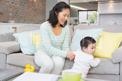 Happy mother with baby daughter in the living room